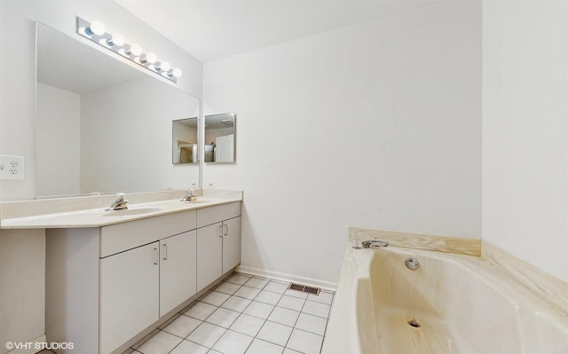 bathroom with tile patterned floors, a bathing tub, and vanity