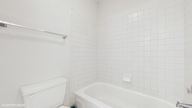 bathroom featuring tiled shower / bath combo and toilet