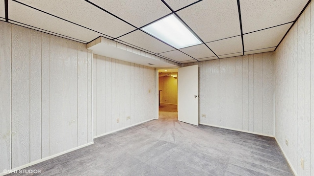 basement featuring a paneled ceiling and carpet