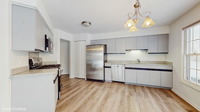 kitchen with sink, gray cabinets, appliances with stainless steel finishes, decorative light fixtures, and a chandelier