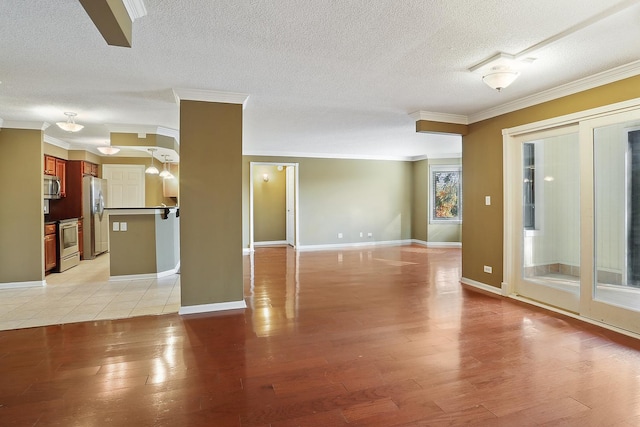 unfurnished room featuring crown molding, light hardwood / wood-style flooring, and a textured ceiling