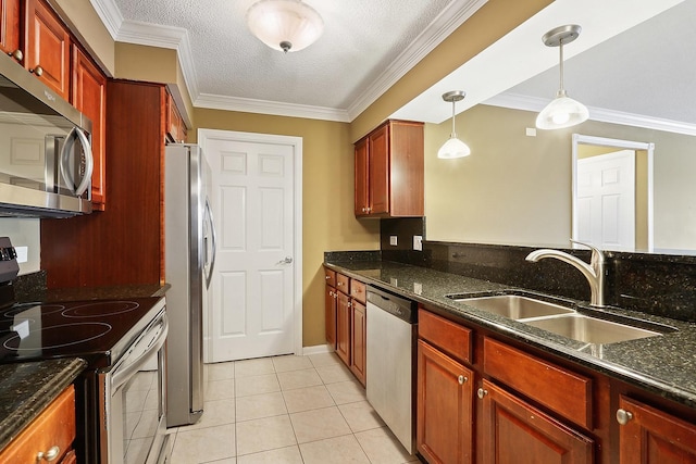 kitchen with appliances with stainless steel finishes, sink, light tile patterned floors, dark stone countertops, and hanging light fixtures