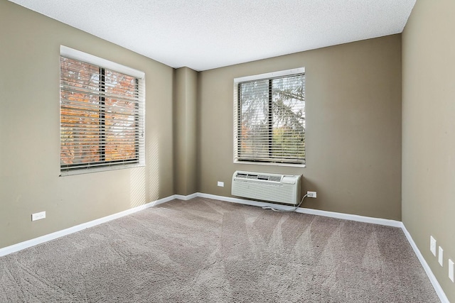 carpeted empty room with a textured ceiling and a wall mounted air conditioner