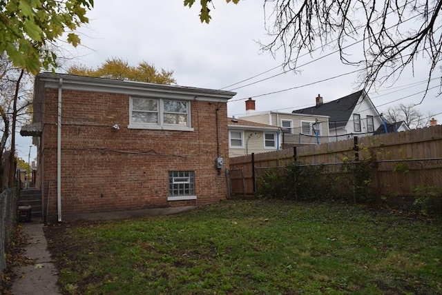 rear view of property featuring a lawn