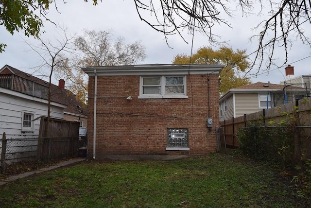 rear view of property with a lawn