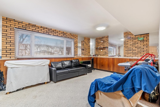 carpeted living room with brick wall