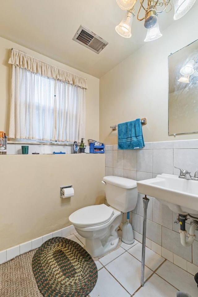 bathroom with tile patterned flooring, toilet, and tile walls