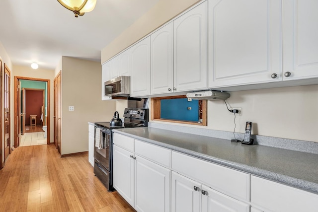 kitchen featuring black electric range, light hardwood / wood-style flooring, and white cabinetry