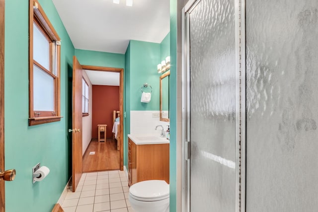 bathroom featuring tile patterned floors, vanity, an enclosed shower, and toilet