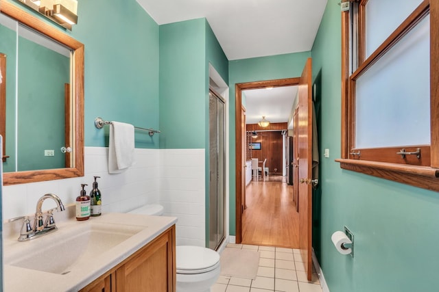 bathroom with tile patterned flooring, vanity, toilet, and a shower with shower door