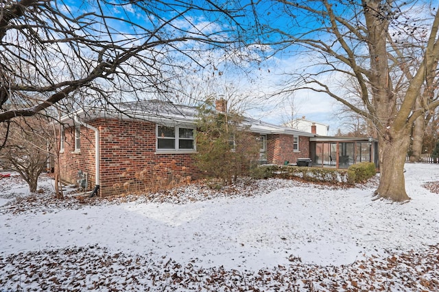 snow covered house with a sunroom