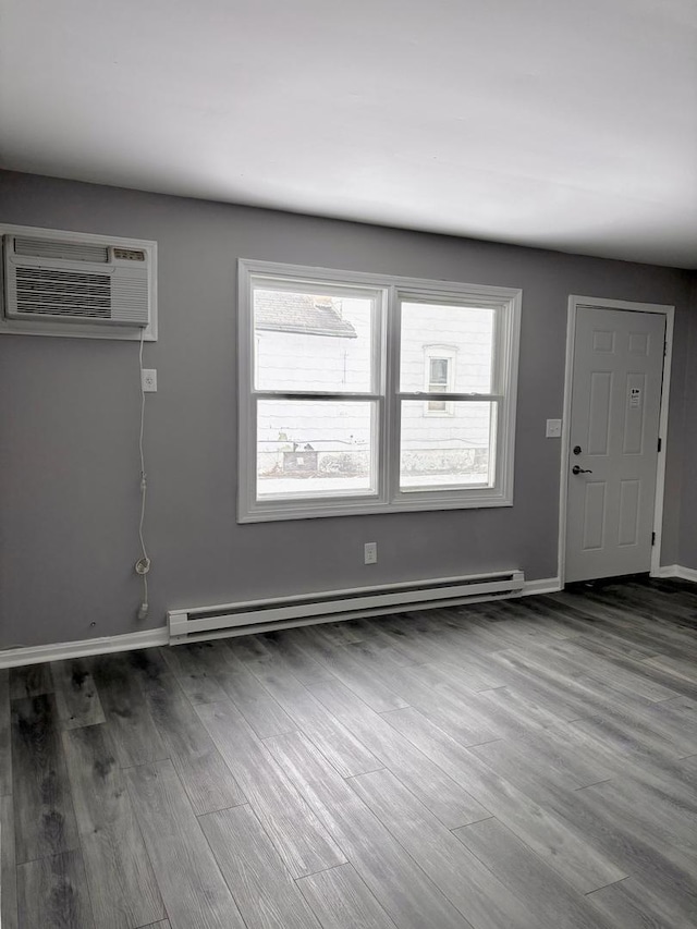 foyer with dark hardwood / wood-style flooring, a baseboard radiator, and an AC wall unit