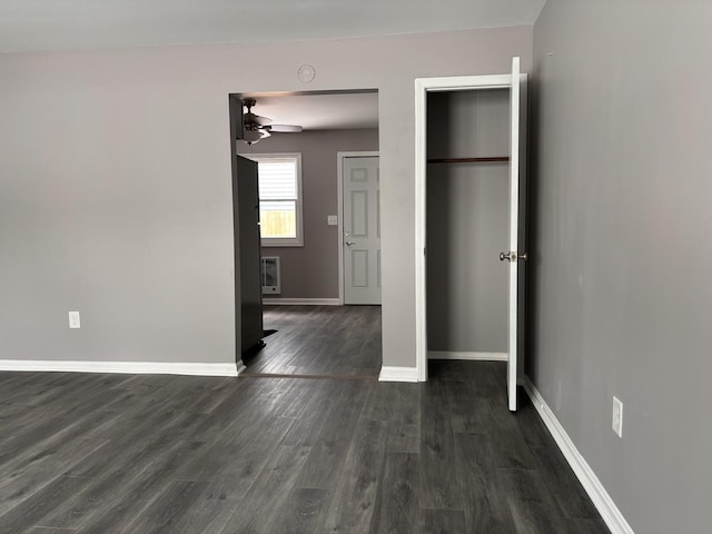 unfurnished bedroom featuring dark hardwood / wood-style floors, refrigerator, and a closet