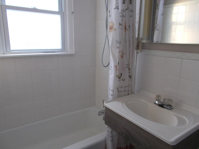 bathroom with shower / bath combination with curtain, sink, and tile walls