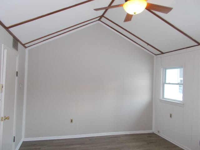 unfurnished room with dark hardwood / wood-style floors, vaulted ceiling, and ceiling fan