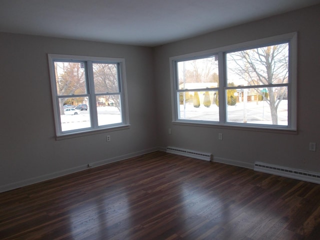 spare room with dark hardwood / wood-style floors and baseboard heating