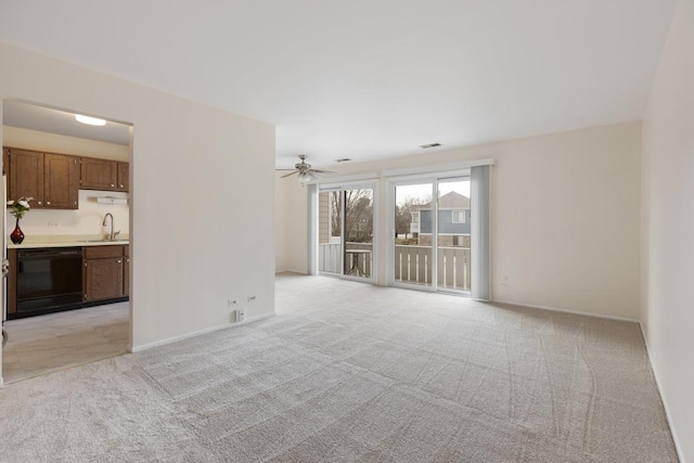 unfurnished living room featuring ceiling fan, sink, and light carpet