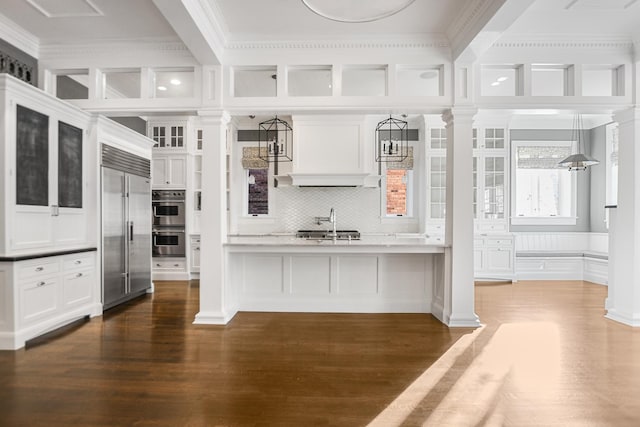 kitchen featuring white cabinets, decorative light fixtures, dark hardwood / wood-style flooring, and stainless steel appliances