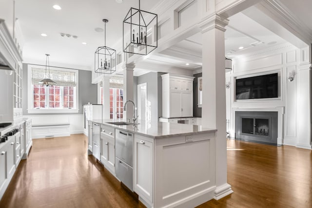 kitchen featuring light stone counters, dark wood-type flooring, sink, pendant lighting, and white cabinets