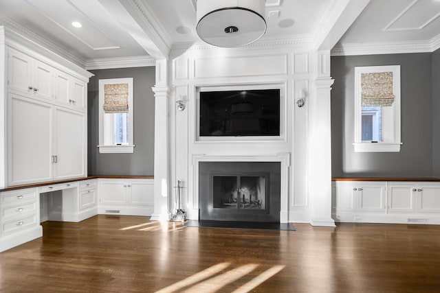 unfurnished living room featuring crown molding, built in desk, and dark wood-type flooring