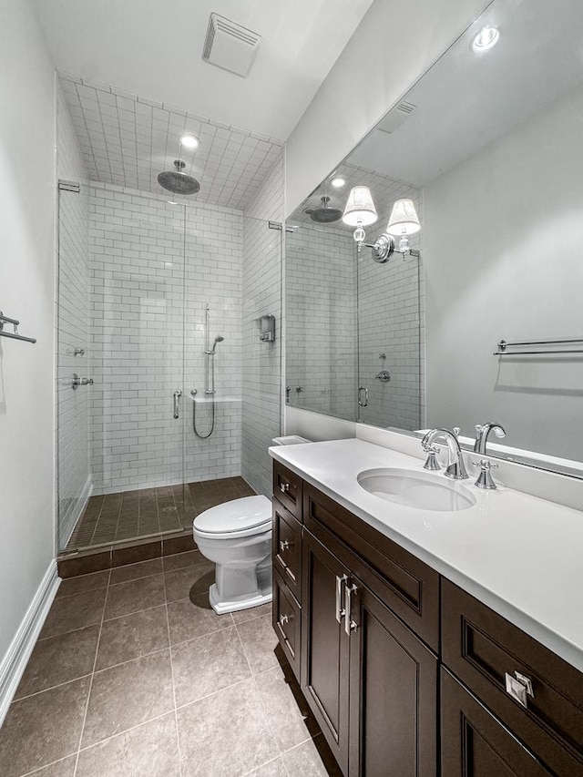 bathroom featuring tile patterned floors, vanity, toilet, and a shower with shower door