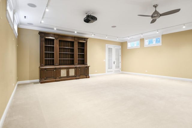 carpeted spare room featuring ceiling fan, ornamental molding, and rail lighting