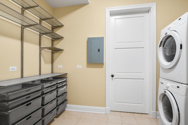 laundry area with electric panel, light tile patterned floors, and stacked washer / drying machine