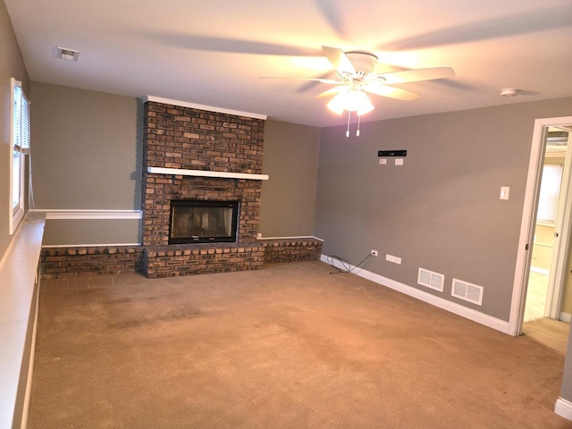 unfurnished living room with carpet flooring, a brick fireplace, and ceiling fan