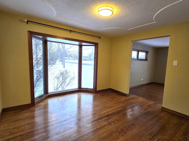 empty room featuring dark hardwood / wood-style flooring and a textured ceiling