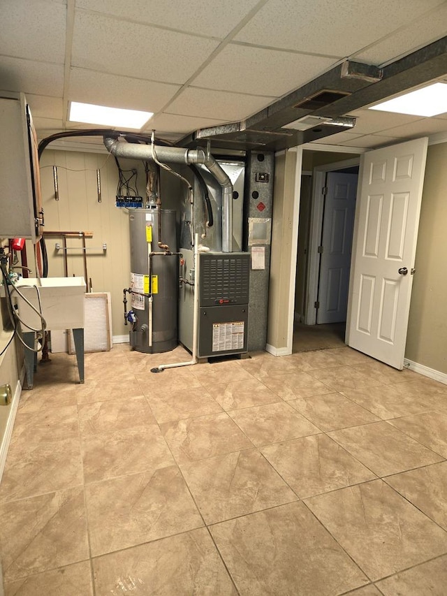 interior space with heating unit, a drop ceiling, and water heater