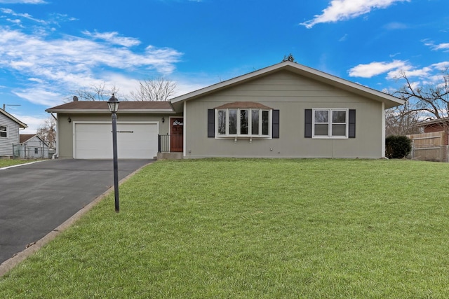 ranch-style house featuring a garage and a front lawn