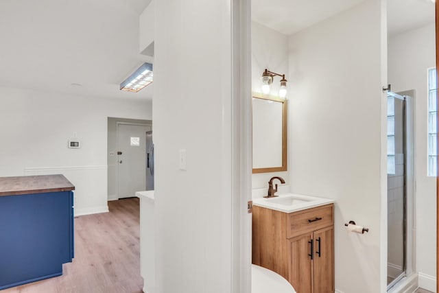 bathroom with hardwood / wood-style floors, vanity, and walk in shower