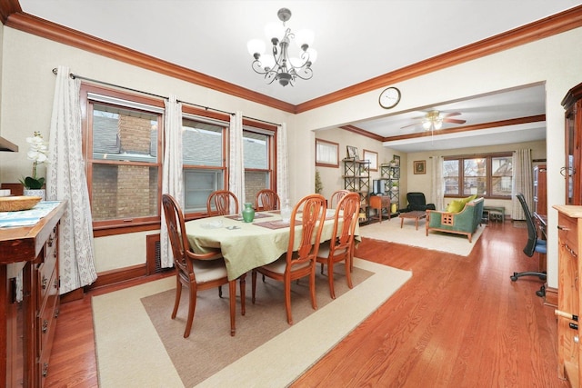 dining room with ceiling fan with notable chandelier, wood-type flooring, and crown molding