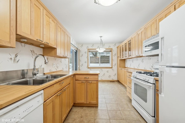 kitchen featuring sink, pendant lighting, white appliances, light brown cabinetry, and light tile patterned floors