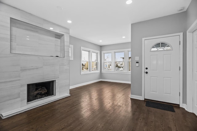 entryway with a tile fireplace and dark hardwood / wood-style floors