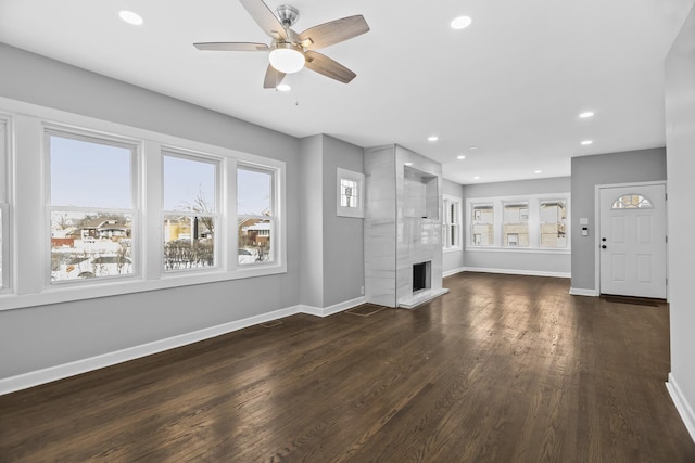 unfurnished living room featuring ceiling fan, dark wood-type flooring, and a premium fireplace