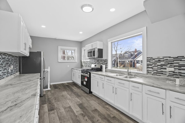 kitchen with dark hardwood / wood-style floors, white cabinetry, sink, and appliances with stainless steel finishes