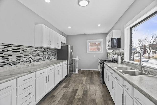 kitchen featuring white cabinets, stainless steel appliances, tasteful backsplash, and sink