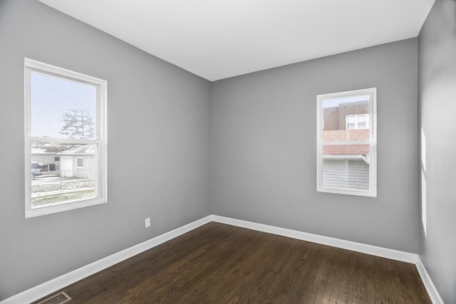 spare room featuring hardwood / wood-style flooring and a healthy amount of sunlight