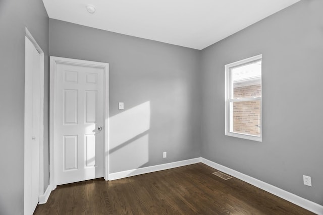 unfurnished room featuring dark hardwood / wood-style floors and a healthy amount of sunlight