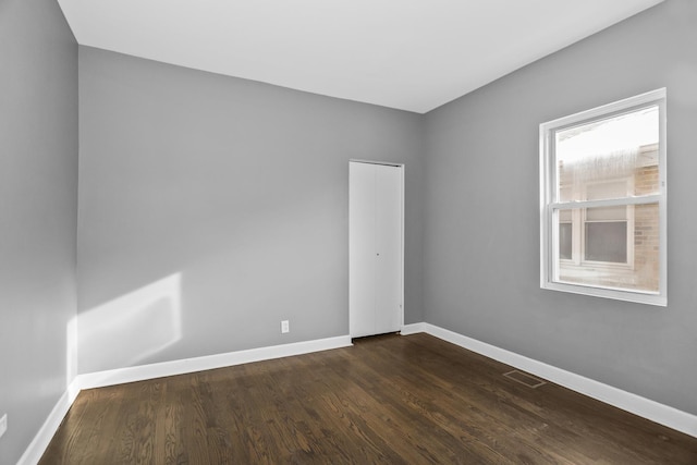 unfurnished room with dark hardwood / wood-style floors