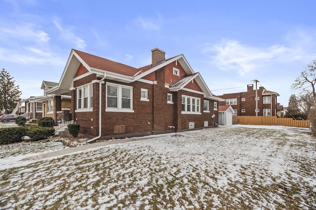 snow covered property featuring a storage unit