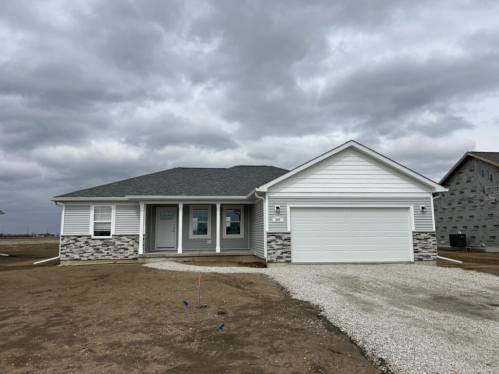 unfinished property featuring a garage and a porch