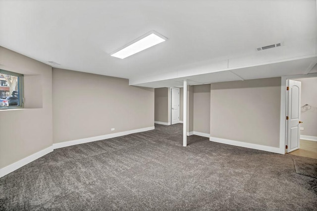 below grade area with carpet flooring, visible vents, and baseboards