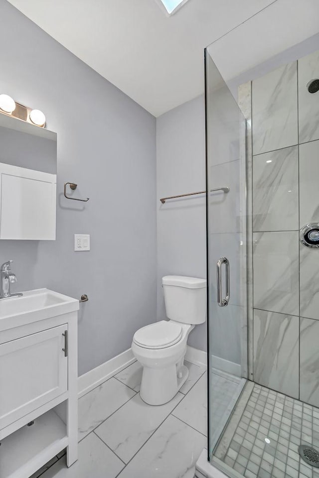 bathroom featuring marble finish floor, toilet, a shower stall, vanity, and baseboards