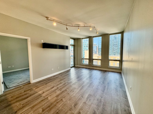 spare room with hardwood / wood-style floors and track lighting