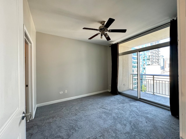 carpeted empty room with a wall of windows and ceiling fan