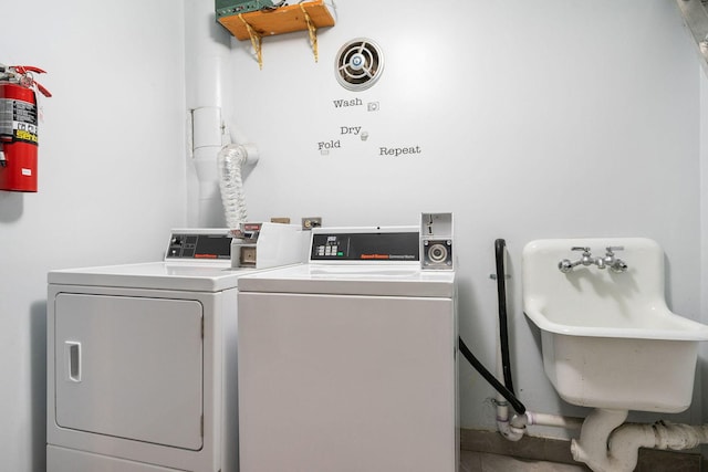 clothes washing area with washing machine and dryer and sink