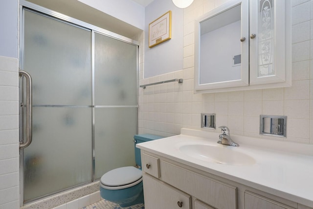 bathroom with an enclosed shower, vanity, toilet, and tile walls