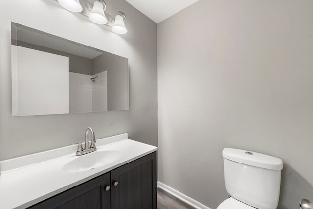 bathroom featuring a shower, vanity, and toilet